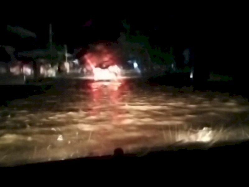 Jalan Poros di Allu, Kecamatan Bangkala, Kabupaten Jeneponto banjir hingga lalu lintas terhambat.  Rabu, 16 November 2022 malam. 