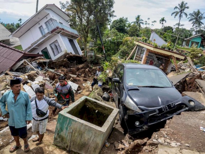 (Foto dari Putra M Akbar jurnalis Republika): Warga melewati jalan yang rusak akibat gempa di Desa Sarampad, Kecamatan Cugenang, Kabupaten Cianjur, Jawa Barat, Selasa (22/11/2022). Gempa di Kabupaten Cianjur, Jawa Barat, mengakibatkan sejumlah rumah dan jalan rusak parah di Desa Sarampad. Akibatnya, kendaraan tidak bisa melintas untuk membawa bantuan bagi warga terdampak.