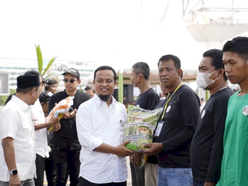 Gubernur Sulawesi Selatan, Andi Sudirman Sulaiman, membagikan bantuan benih padi andalan kepada petani. 