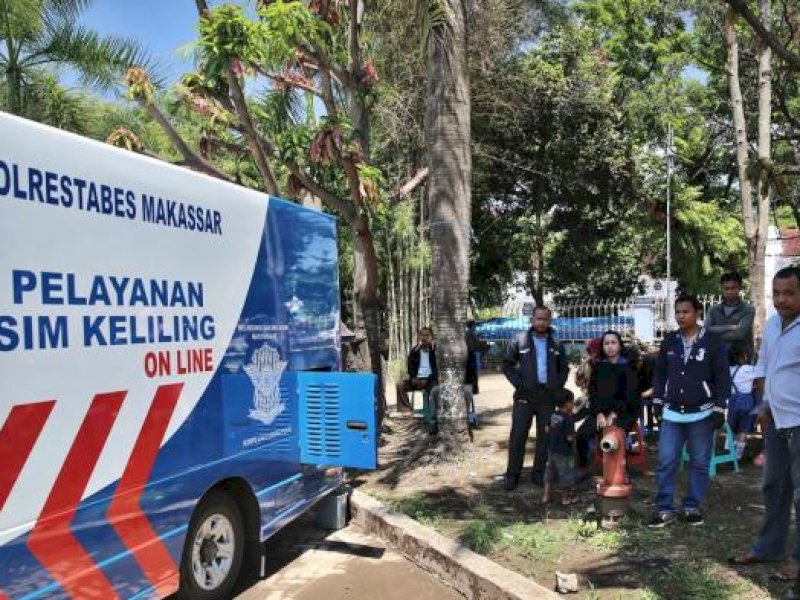 Petugas Polrestabes Makassar melayani warga yang akan melakukan perpanjangan Surat Izin Mengemudi (SIM) C dengan sistem internet berbasis online menggunakan mobil pelayanan SIM keliling, di pelataran monumen Mandala Makassar. (Foto: TRIBUN TIMUR/ MUH ABDIWAN)