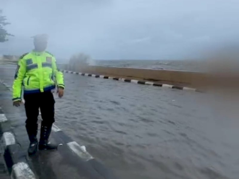 Ipda Kadir Jailani, dari Satlantas Polres Parepare memantau banjir rob di sepanjang Jl Mattirotasi, Jumat (23/12/2022). Jejakfakta/Istimewa