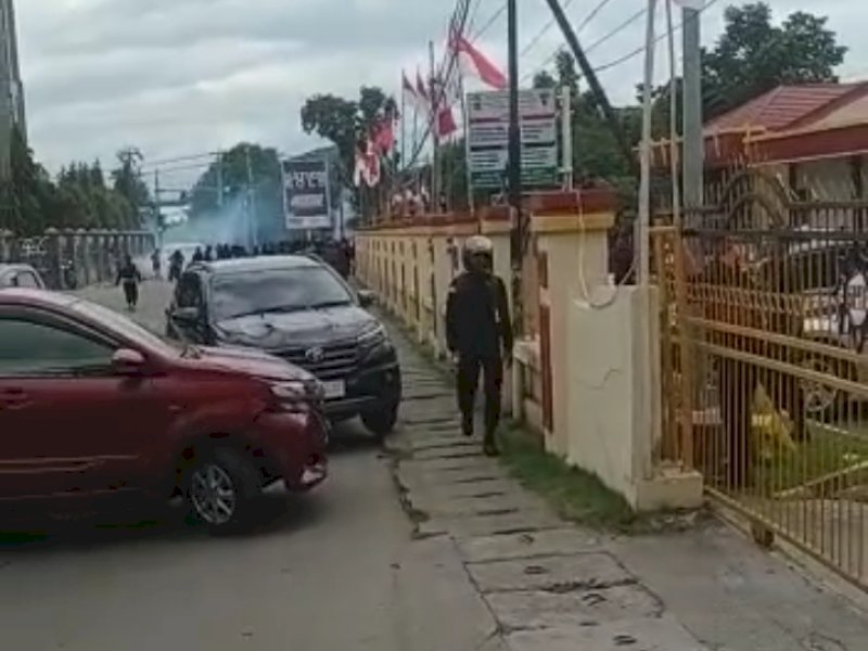 Anggota Brimob melepaskan tembakan ke arah massa di depan Mako Brimob Papua. Dikabarkan KPK tangkap Lukas Enembe. @Jejakfakta/Ist.