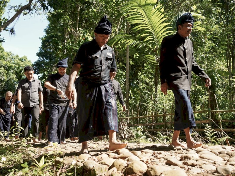 Bupati Bulukumba Andi Muctar Ali Yusuf berjalan menggunakan pakaian hiltam hitam di kawasan Adat Ammatoa Kajang. @Jejakfakta/Dok. Humas Pemkab Bulukumba