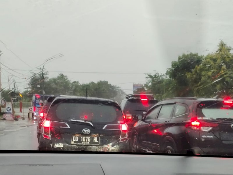 Di tengah hujan mengguyur, arus lalu lintas di kilometer 14 Jl Perintis Kemerdekaan, kota Makassar terpantau macet, Senin (13/2/2023) pagi ini.