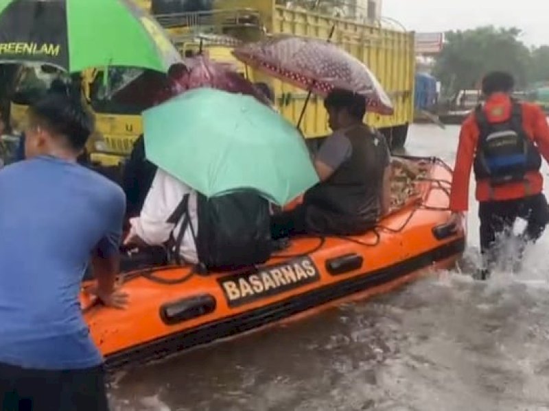Tim Basarnas Sulsel melakukan evakuasi warga yang terdampak banjir di Makassar. @Jejakfakta/dok