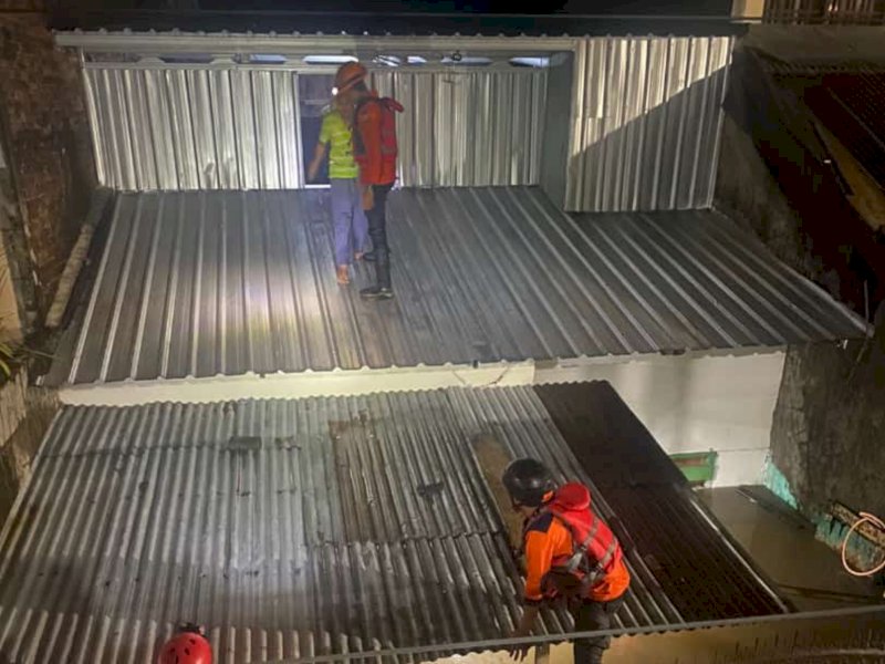 Tim BPBD Makassar mengevakuasi korban banjir lewat atap rumah di Blok 10 Perumnas Antang, Kecamatan Manggala, kota Makassar, Senin (13/2/2023) malam Wita.