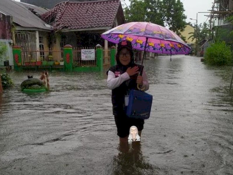 Tim Pantarlih harus menerobos banjir untuk menjalankan tugas pemutakhiran data pemilih di Makassar, Kamis (16/2/2023). @Jejakfakta/Ist. 