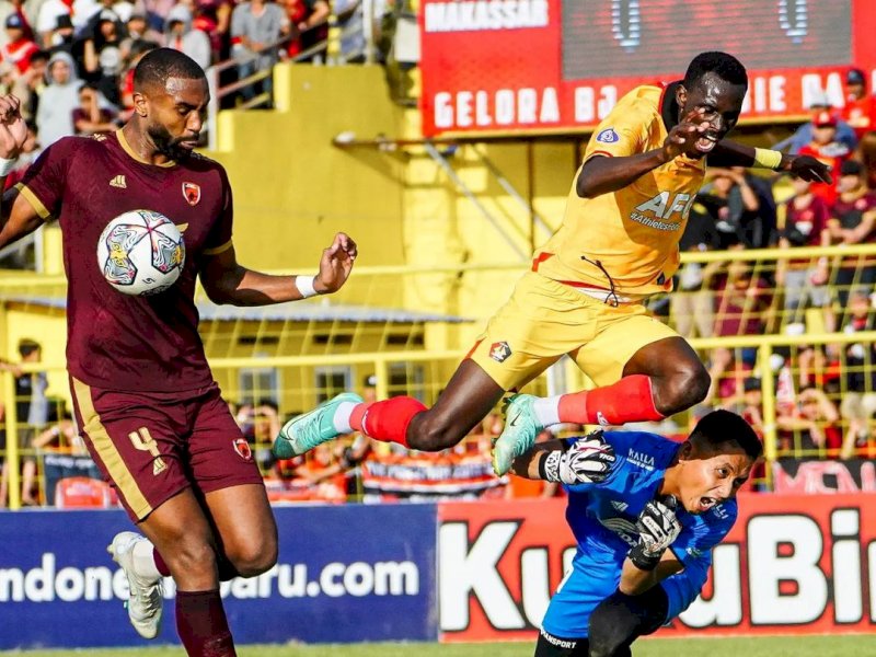 Kiper PSM Makassar, Muhammad Reza Pratama (bawah) saat menghalau serangan dari penyerang Persik Kediri, Fl&aacute;vio Silva. @Persik Kediri Official 
