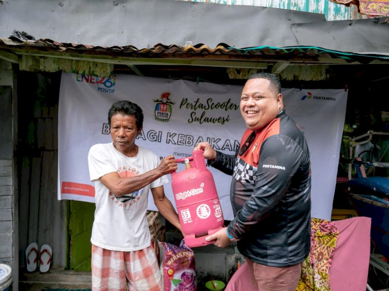 Ketua PertaScooter Sulawesi, Adenan menyerahkan langsung bantuan sembako kepada warga. @Jejakfakta/ist.