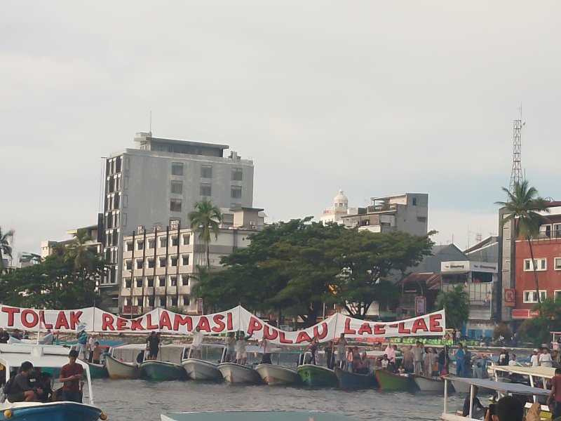 Masyarakat pisisir Makassar dari Pulau Lae-Lae unjuk rasa dengan parade perahu di barat Pantai Losari menghadap ke kawasan reklamasi Center Point of Indonesia (CPI), kota Makassar, Sabtu (4/3/2023). Mereka aksi menolak rencana Pemprov Sulsel melalui pengembang CPI PT Yasmin Bumi Asri menimbun Pulau Lae-Lae.