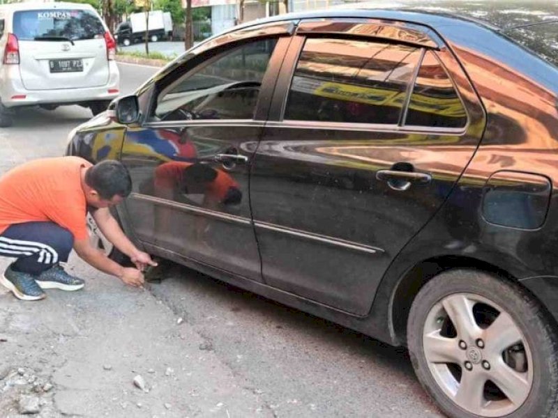 Warga mengabadikan gambar Gubernur Andi Sudirman Sulaiman turun tangan menangani mobil Fitriana, di pinggir Jl Gunung Latimojong, Kelurahan Maradekaya, Kecamatan Makassar, 3 Km sebelah timur Losari, kota Makassar, Ahad (12/3/23) pagi Wita.