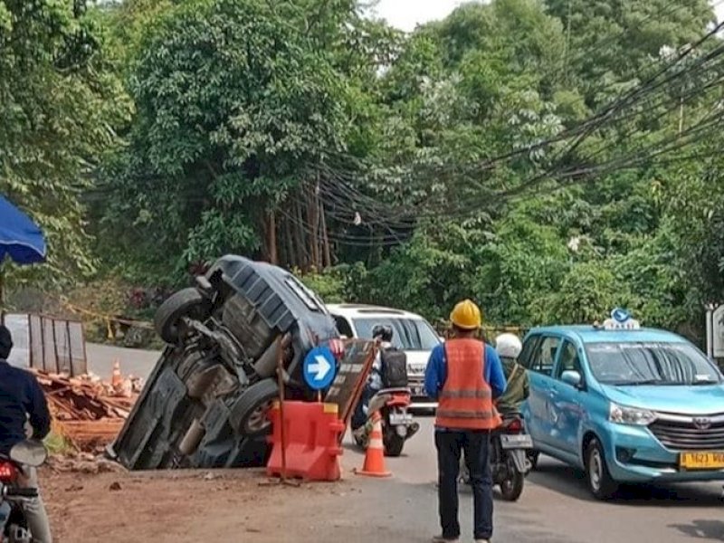 Lubang galian di tengah jalan Taman Margasatwa Raya, Ragunan, Pasar Minggu, Jakarta Selatan, menelan kendaraan roda empat, Senin (13/3/23) siang. Kejadian ini viral. 