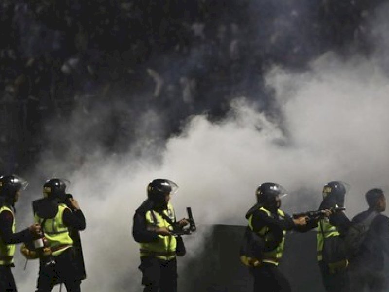 Polisi menembak gas air mata untuk membubarkan massa di Stadion Kanjuruhan, Malang, 1 Oktober 2022. (AP/Yudha Prabowo).