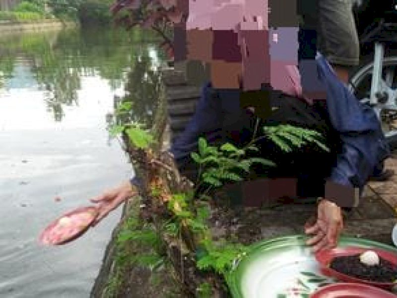 Warga memberi sesajen ke Sungai Pampang, kota Makassar, Sulawesi Selatan. Sesajen berisi songkolok, telur ayam kampung dan makanan berbahan daging ayam. (Liputan6.com/Eka Hakim).