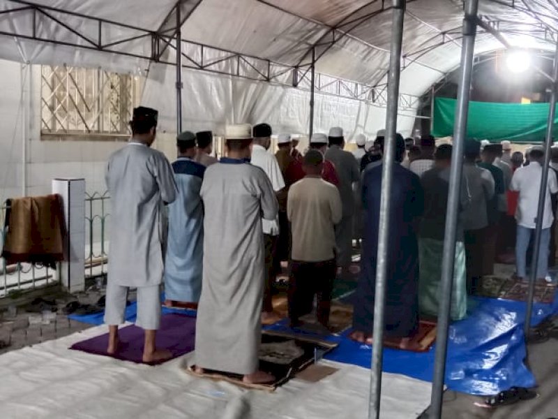 Jemaah Masjid Ittifaqul di Jl. Barukang 1 Makassar melaksanakan salat dengan mendirikan tenda darurat, Senin (27/3/2023). @Jejakfakta/Samsir