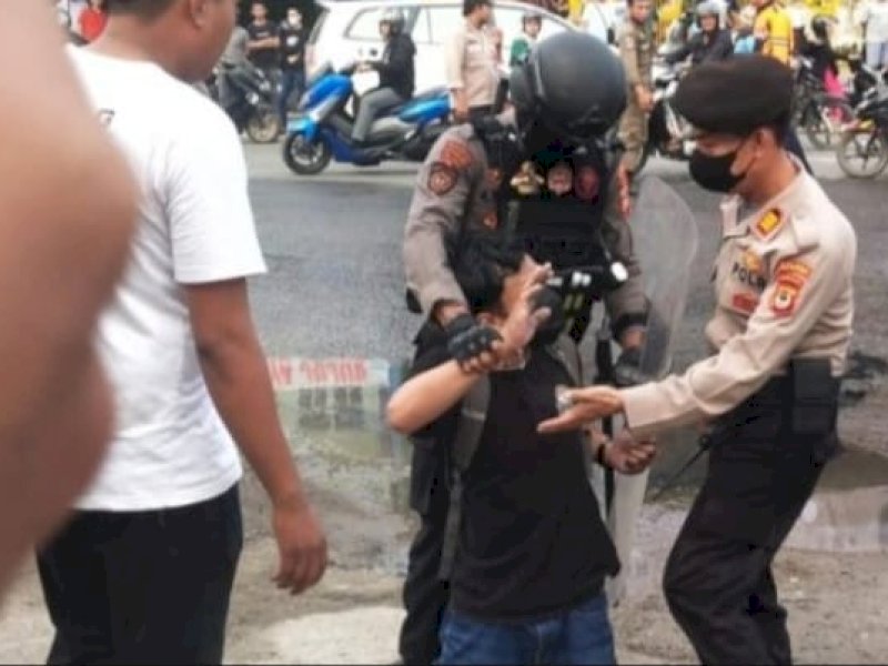 Dirman Saso dari media MNC TV diduga mengalami tindakan kekerasan oleh anggota kepolisian yang melakukan pengamanan. @Jejakfakta/ist.