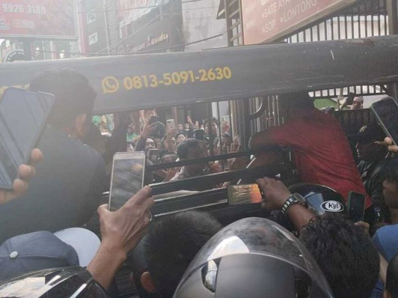 Pelaku penyanderaan bayi 2 bulan yang dievakuasi polisi menggunakan mobil patroli dengan tangan terborgol di Jalan Baruga Raya, Kecamatan Manggala, Kota Makassar, Sulsel, Rabu (24/5/2023). @dok. Kompas.com