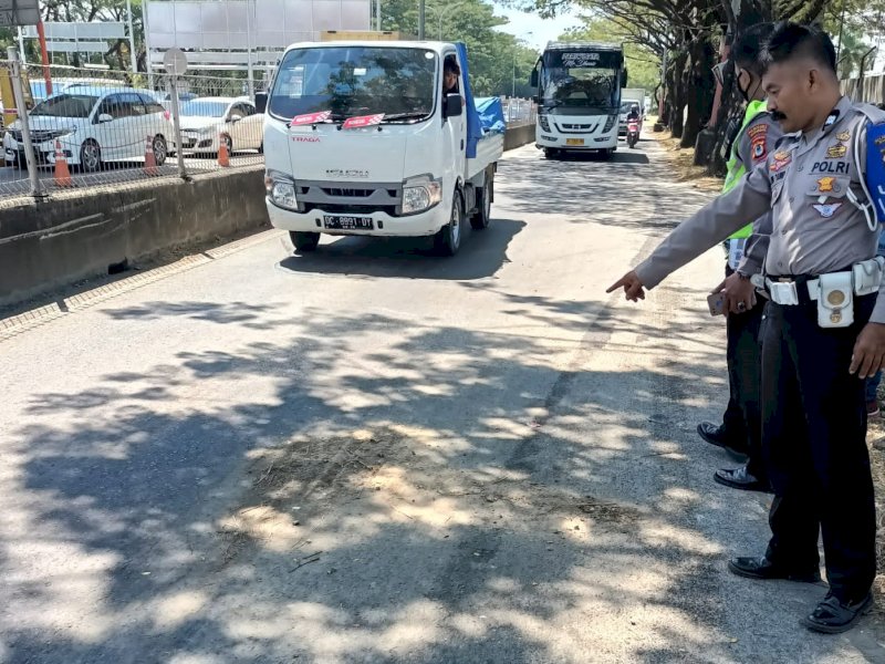 Polisi dari Unit Laka Lantas Polrestabes mempelihatkan lokasi kecelakaan di Jl. Ir. Sutami, Biringkanaya, Kota Makassar, Selasa (30/5/2023). @Jejakfakta/Samsir