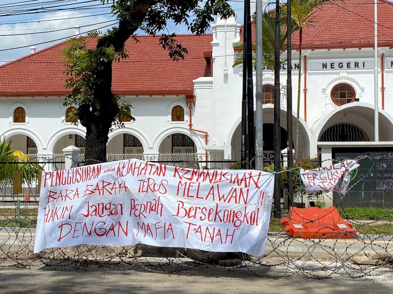 Tolak Penggusuran. Aliansi Bara-Baraya Bersatu memasang sejumlah spanduk penolakan penggusuran warga Bara-baraya yang dinilai sebagai kejahatan kemanusiaan, di depan Pengadilan Makassar, Selasa (13/06/2023). @Jejakfakta/Atri