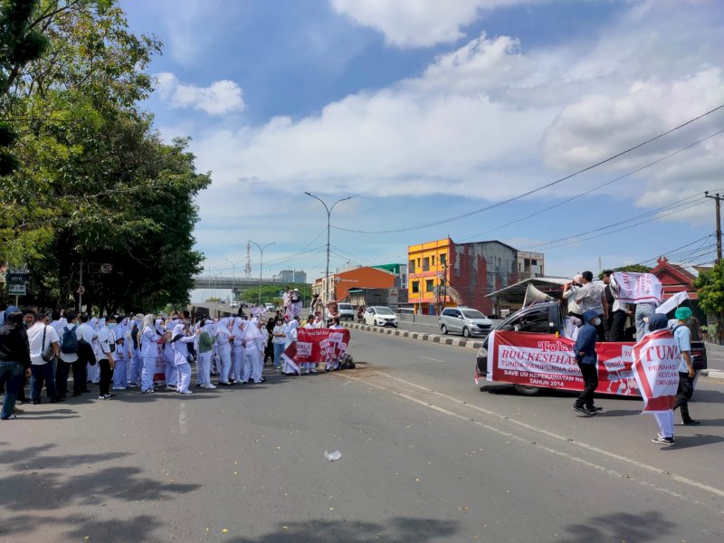 Ratusan mahasiswa yang tergabung dalam Aliansi Perawat Sulawesi Selatan melakukan unjuk rasa penolakan terhadap RUU Kesehatan di depan kantor DPRD Sulsel, Selasa (11/7/2023). @Jejakfakta/Atri