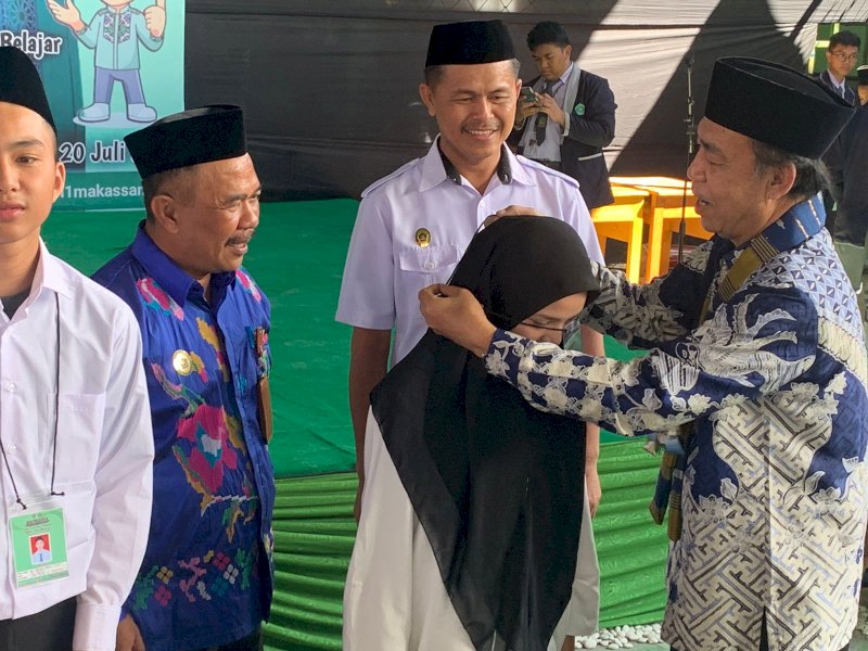 Ketua Komisi VIII DPR RI, Ashabul Kahfi memasang kalung dimulainya prosesi penyambutan siswa baru di Madrasah Aliyah Negeri (MAN) 1 Kota Makassar, Senin (17/7/2023). @Jejakfakta/dok MAN 1 Makassar