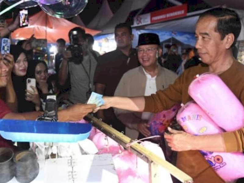 Presiden Jokowi membeli gulali di Festival Tabut di Kota Bengkulu, Rabu (19/07/2023) malam. (Foto: BPMI Setpres).