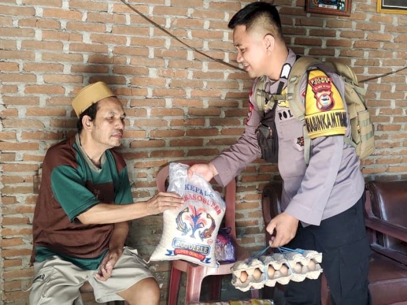 Bripka Aswin Jahar, personil kepolisian Bhabinkamtibmas Polsek Bajeng, Kabupaten Gowa, berbagi sembako kepada kaum dhuafa. @Jejakfakta/dok. Istimewa