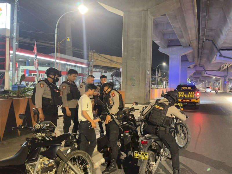 Sejumlah aparat keamanan dari Samapta Polrestabes Makassar mengamankan sejumlah pemuda yang kerap aksi balap liar di jalan raya. @Jejakfakta/Samsir