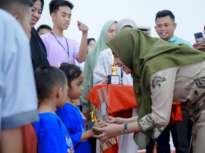 Bunda Forum Anak Pangkep, Nurlita Wulan Purnama memberikan piala penghargaan dalam lomba puisi tingkat Sekolah Dasar dan mewarnai tingkat TK. @Jejakfakta/dok. Humas Pangkep