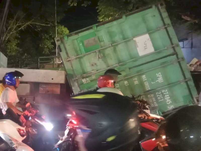 Sebuah mobil kontainer mengalami kecelakaan di jalan Galangan Kapal, Kecamatan Tallo, Makassar, Selasa (31/10/2023). Box kontainer tersebut menimpa dua mobil dan dua buah unit kendaraan motor. @Jejakfakta/Samsir