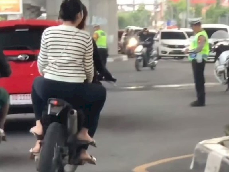Tangkapan layar video viral pengendara melintas di depan polisi tidak memakai helm. @Jejakfakta/Samsir 