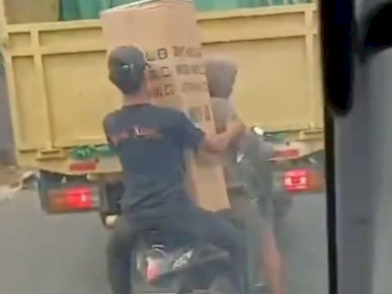 Dua remaja terekam saat melakuan aksi pencurian di atas mobil truk yang sedang berjalan di Jalan Galangan Kapal Makassar. Keduanya sudah diamankan polisi. @Jejakfakta/Tangkapan Layar