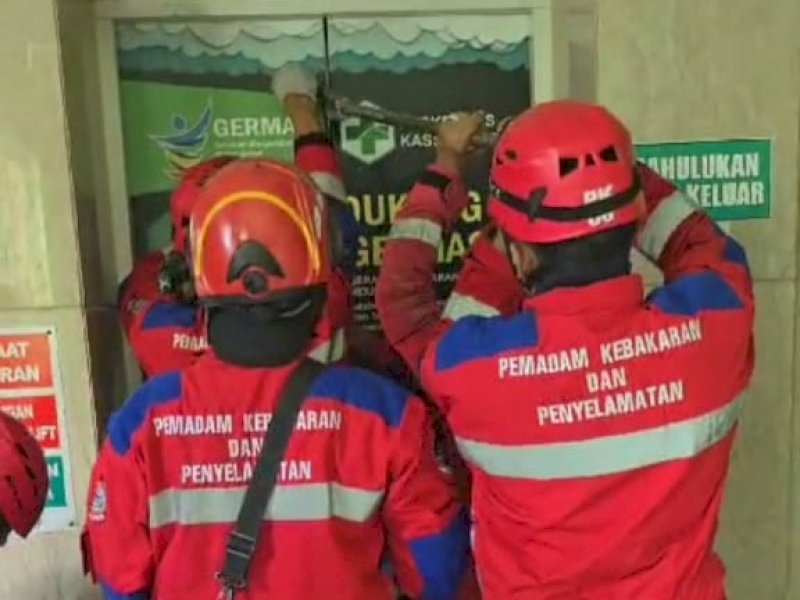Perugas Damkar Kota Makassar melakukan evakuasi terhadap petugas Puskesmas Kassi-Kassi yang terjebak di lift, Senin (4/3/2024). @Jejakfakta/Tangkapan Layar