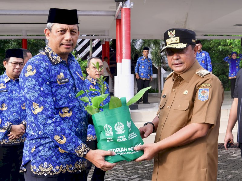 Pjm Gubernur Sulse Bahtiar Baharuddin menyerahkan secara simbolik dalam Program Sedekah Pohon usai mengikuti Upacara Bendera yang diadakan di Lapangan Kantor Gubernur, pada Rabu (17/4/2024). @Jejakfakta/dok. Humas Pemprov Sulsel