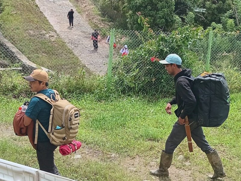 Tenaga kesehatan yang disiagakan di Posko Induk Penanganan Bencana di Kabupaten Luwu rela berjalan kaki untuk melayani warga terdampak banjir dan tanah longsor, termasuk di titik yang masih terisolir. @Jejakfakta/dok. Humas Pemprov Sulsel