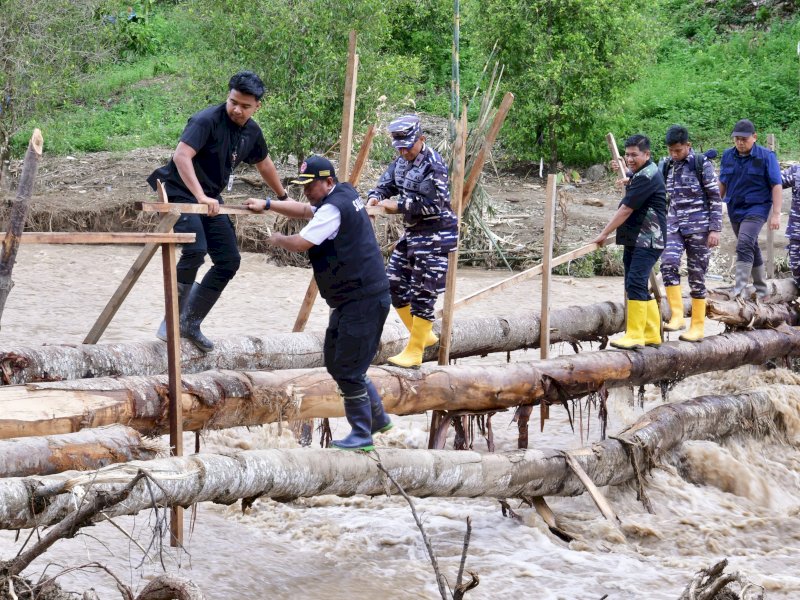 Penjabat Gubernur Sulsel, Bahtiar Baharuddin, melewati jembatan darurat di tengah arus sungai yang sangat deras untuk menemui warga terdampak banjir dan tanah longsor yang terisolir di Kecamatan Latimojong, Kabupaten Luwu, Kamis (9/5/2024). @Jejakfakta/dok. Humas Pemprov Sulsel