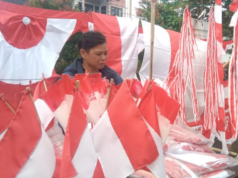Indri menjajakan jualan bendera merah putih di trotoar Jalan Sultan Alauddin, Kota Makassar. @Jejakfakta/Samsir