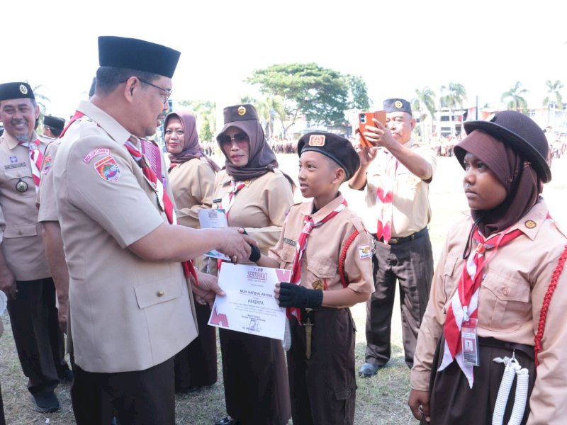 Wakil Bupati Bulukumba, Andi Edy Manaf, memberikan sertifikat peserta pada Apel Besar Gerakan Pramuka dalam rangka memperingati Hari Pramuka ke-63 Tahun 2024 yang berlangsung di Lapangan Pemuda, Rabu (14/8/2024). @Jejakfakta/dok. Humas Pemkab Bulukumba