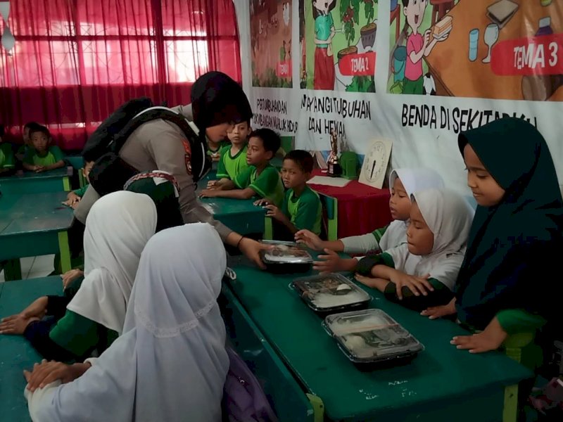 Polisi berbagi makanan bergizi di Sekolah Dasar (SD) Inpres Kampus IKIP, Jalan Raya Pendidikan Blok G, Kelurahan Tidung, Kecamatan Rappocini, Makassar, Jumat (13/9/2024) pagi. @Jejakfakta/Samsir