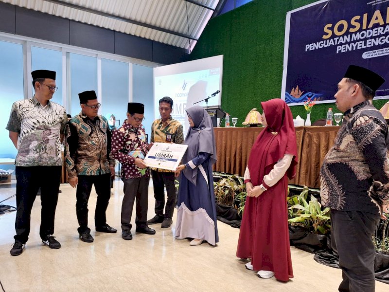 Kepala Kanwil Kemenag Sulsel, HM. Tonang menyerahkan paket umrah kepada Ma'rifah asal Pangkep, juara dua tilawah remaja putri dan Latiffatul Syaroh asal Luwu Utara, juara tiga qiraah murattal dewasa putri di Hotel MaxOne Makassar, Rabu (25/9/2024). @Jejakfakta/dok. Humas Kemenag Sulsel