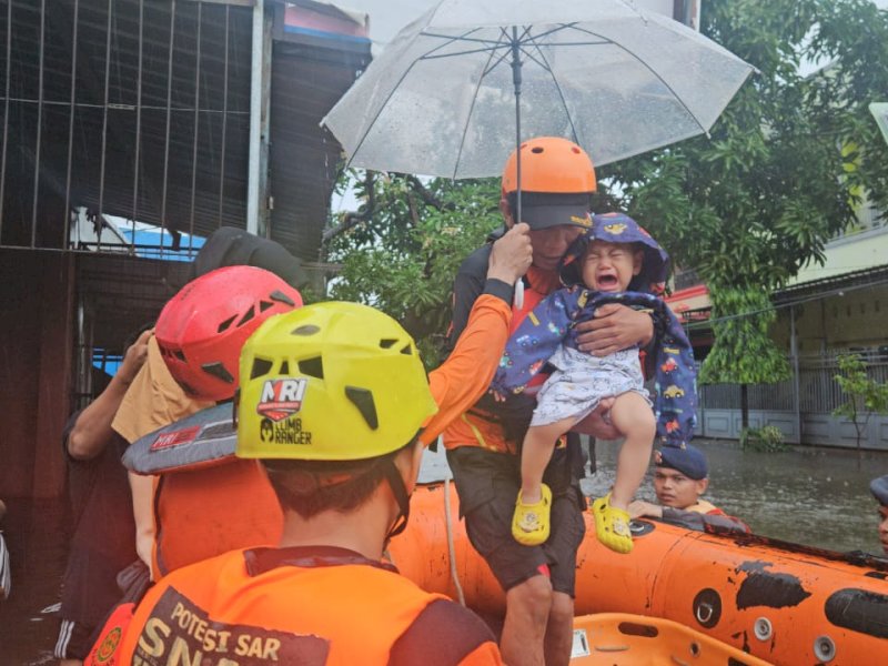 Tim evakuasi menyelematkan seorang bayi terdampak banjir di Kota Makassar, Minggu (22/12/2024). Kemensos kucurkan Rp1,8 Miliar untuk 1.611 pengungsi banjir Makassar dan sekitarnya. @Jejakfakta/dok. Basarnas