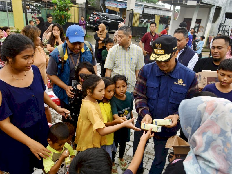 Penjabat Gubernur Sulsel, Zudan Arif Fakrulloh memberikan bantuan susu kepada anak-anak di lokasi pengungsian banjir di Makassar, Sabtu (21/12/2024). @Jejakfakta/Istimewa