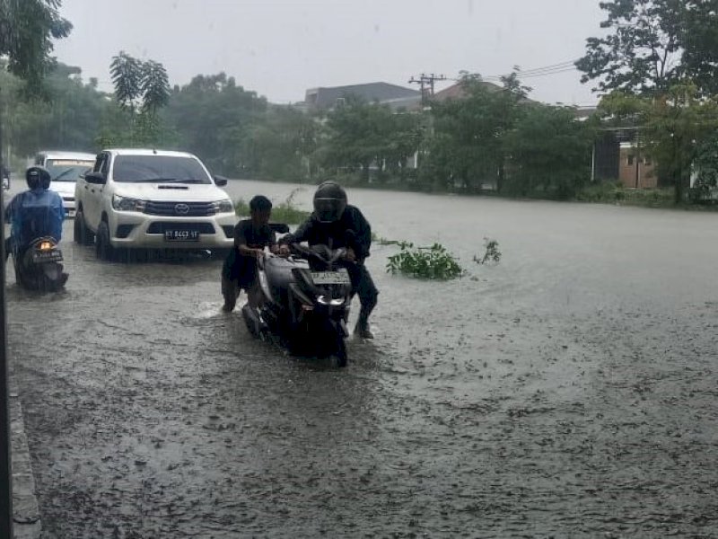 Pengedara motor mogok saat melintas di Jalan Inspeksi Kanal Borong tembusan ke arah Jalan Borong Raya, Kelurahan Borong, Kecamatan Manggala, Kota Makassar, Minggu (22/12/2024). @Jejakfakta/Samsir