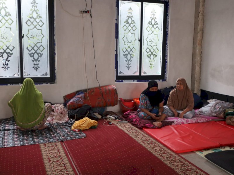 Suriani bersama keluarga di lokasi pengungsian di Masjid Al-Muttaqim, Manggala, Kota Makassar, Minggu (22/12/2024). @Jejakfakta/Samsir