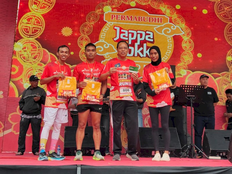 Ketua Permabudhi Sulsel, Yonggris Lao, memberikan hadiah kepada peserta Heritage Run, Minggu (9/2/2025). @Jejakfakta/Istimewa