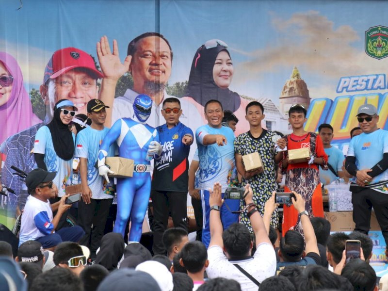 Bupati Luwu Timur, Irwan Bachri Syam, memberikan doorprize langsung kepada tiga peserta berhasil mencuri perhatian karena keberanian mereka tampil unik,  dalam gelaran Fun Run 2025 dan kampanye Anti Mager Sulsel yang digelar di Bundaran Batara Guru, Malili, Ahad pagi (18/05/2025). @Jejakfakta/dok. Humas Pemkab Lutim