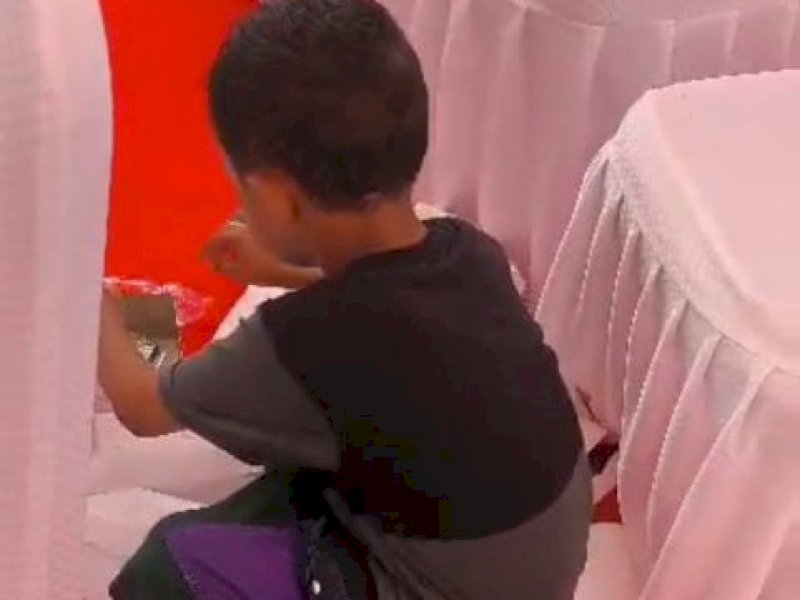 Bocah laki-laki asal Kabupaten Gowa menjadi sorotan publik setelah terekam memungut sisa makanan seusai upacara Hari Ulang Tahun (HUT) ke-80 Republik Indonesia di Lapangan Sultan Hasanuddin, Gowa,Sabtu (17/08/2025). @Jejakfakta/Tangkapan Layar Video Viral