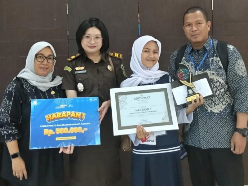 Dwi Maulani, siswi UPT SMP Negeri 3 Angkona (Spentiga), berhasil meraih Juara Harapan I Lomba Pidato Bahasa Inggris bertema Anti Korupsi dalam rangka peringatan Hari Anti Korupsi Sedunia (HAKORDIA) 2025 yang dilaksanakan di Kantor Kejaksaan Tinggi Sulawesi Selatan, Makassar, Selasa (09/12/2025). @Jejakfakta/ikp-humas/kominfo-sp