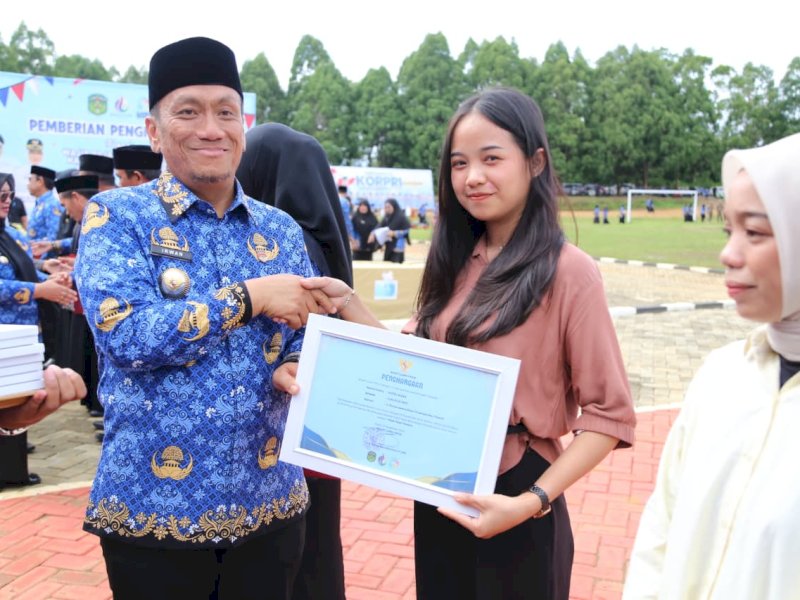 Bupati Luwu Timur, Irwan Bachri Syam, menyerahkan penghargaan kepada 34 wajib pajak daerah berprestasi tahun 2024, bertepatan dengan peringatan HUT KORPRI ke-54 yang berlangsung di Lapangan Pendidikan, Malili, Senin (01/12/2025). @Jejakfakta/dok. IKP-Humas/Kominfo-SP