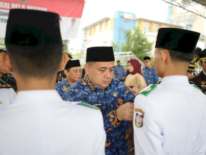 Wali Kota Makassar, Munafri Arifuddin, sematkan Pin Emas sebagai bentuk apresiasi kepada Tim Paskibraka Kota Makassar Tahun 2025, usai Upacara Peringatan Hari Bela Negara ke-77 Tahun 2025 tingkat Kota Makassar di Tribun Lapangan Karebosi, Jumat (19/12/2025). @Jejakfakta/dok. Humas Pemkot Makassar